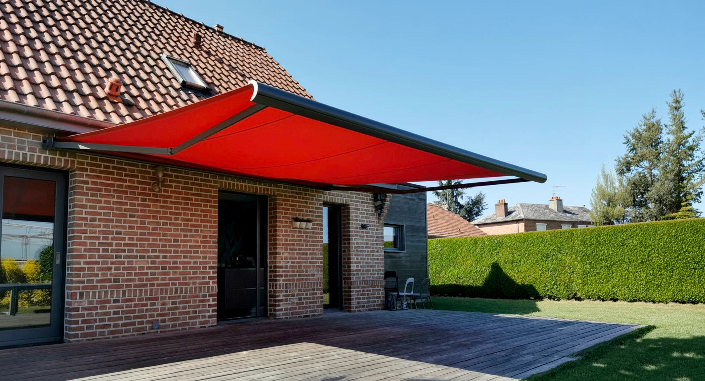 Extension moderne en véranda attenante à maison en briques avec toiture tuiles