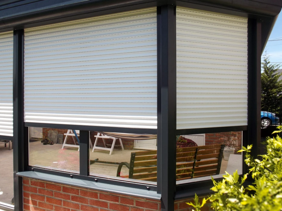 Véranda moderne attenante à maison en briques avec toiture plate métallique