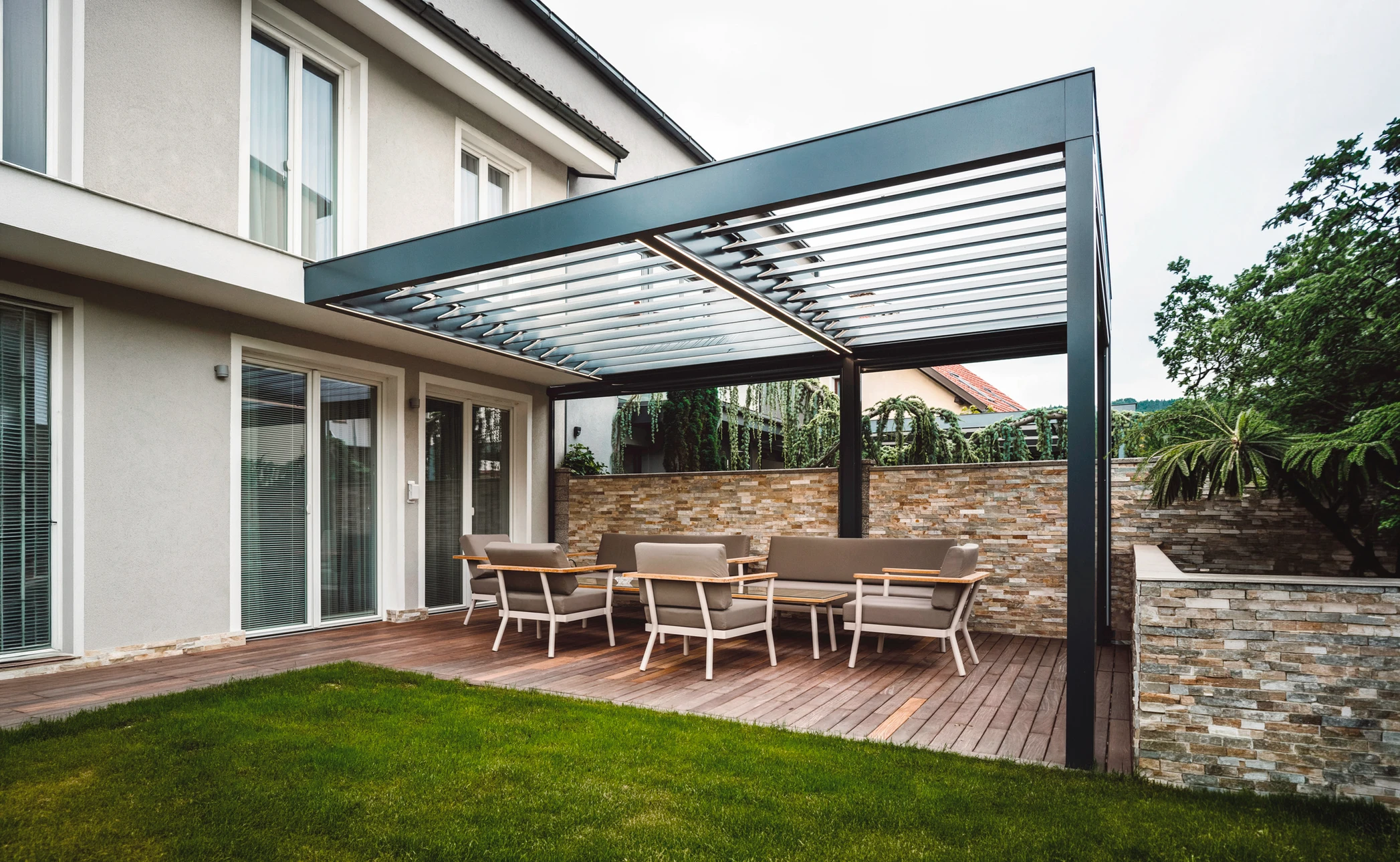 Maison contemporaine avec terrasse couverte ouvrant sur salon moderne par baies vitrées coulissantes